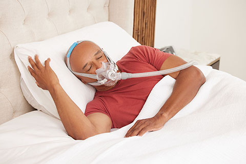 Older Patient Smiling Wearing PAP Mask